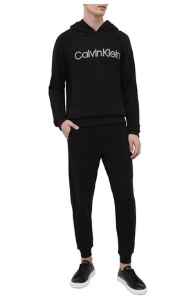 Мужские домашние джоггеры CALVIN KLEIN черного цвета по цене 8215 руб., арт. NM1833E | Фото 2 Мужские домашние джоггеры CALVIN KLEIN черного цвета, арт. NM1833E | Фото 2 (Материал внешний: Синтетический материал, Хлопок; Длина (брюки, джинсы): Стандартные; Кросс-КТ: домашняя одежда; Мужское Кросс-КТ: Брюки-белье)